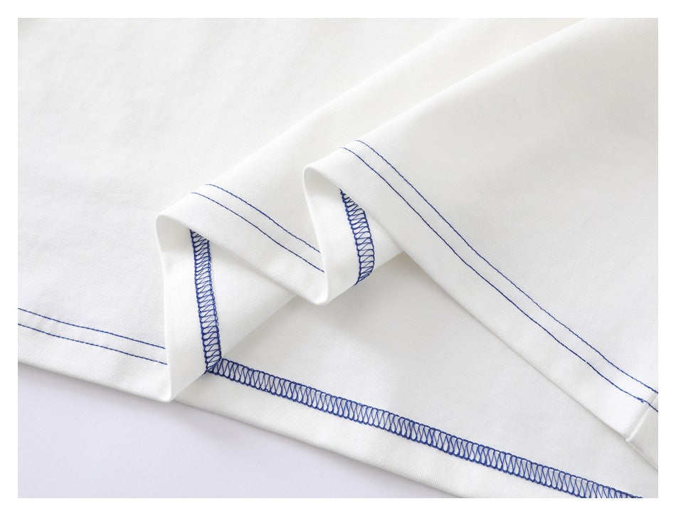 Close-up of a white garment hem showing blue double stitching and overlocked seams.
