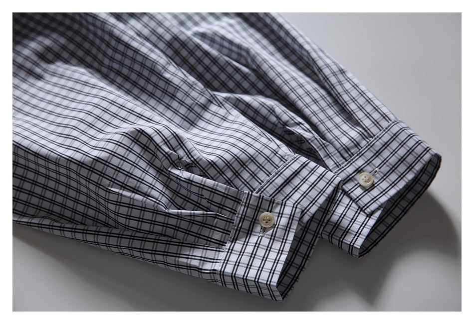 Close-up of black-and-white plaid shirt sleeves with buttoned cuffs.