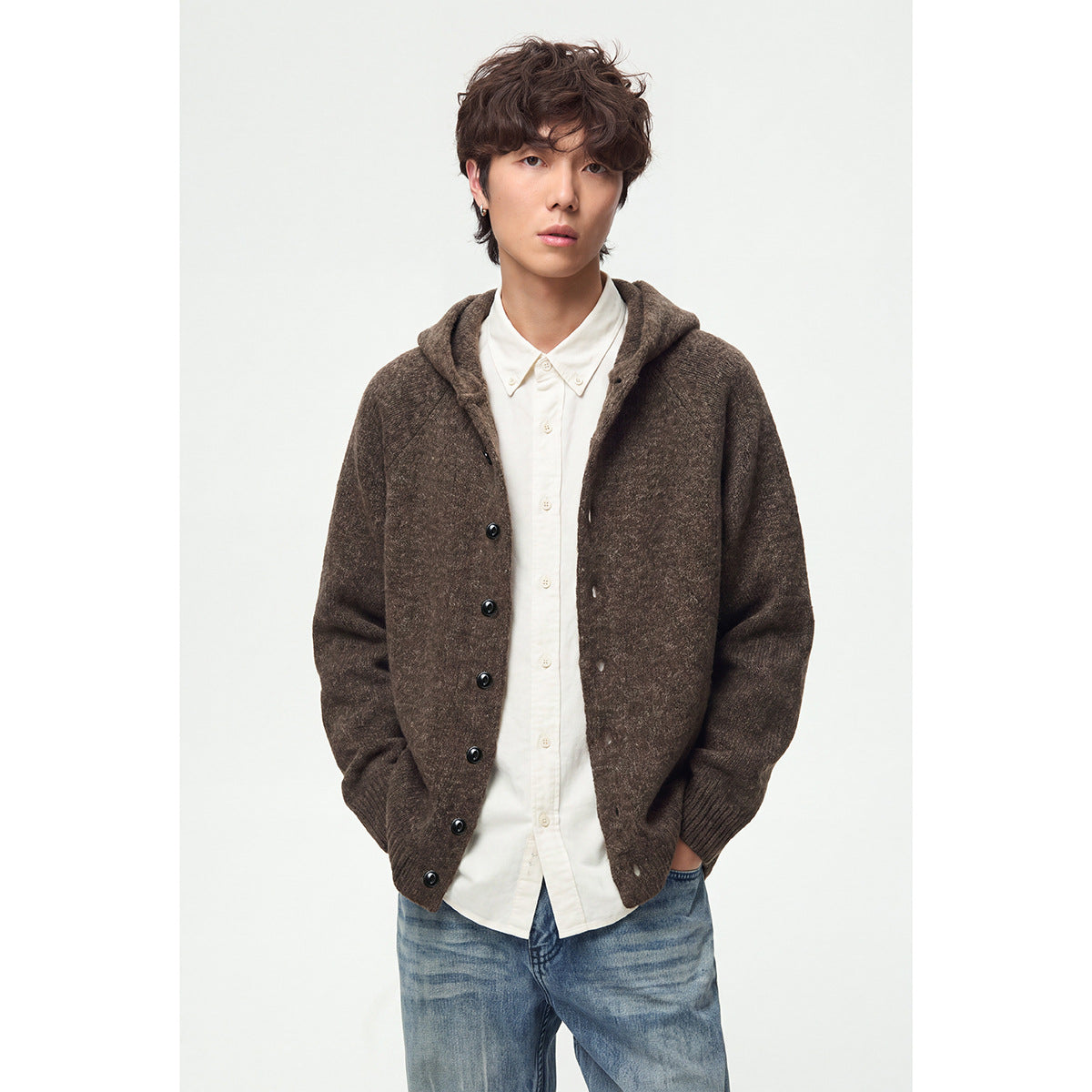 Model wearing a brown hooded button-front cardigan with ribbed cuffs and hem over a white shirt.