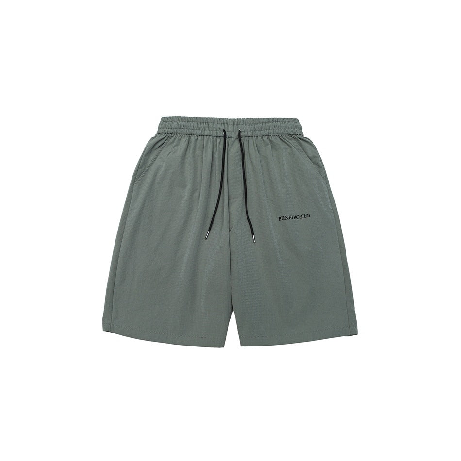 Gray-green knee-length shorts with elastic drawstring waist, side pockets and small embroidered text, front flat lay