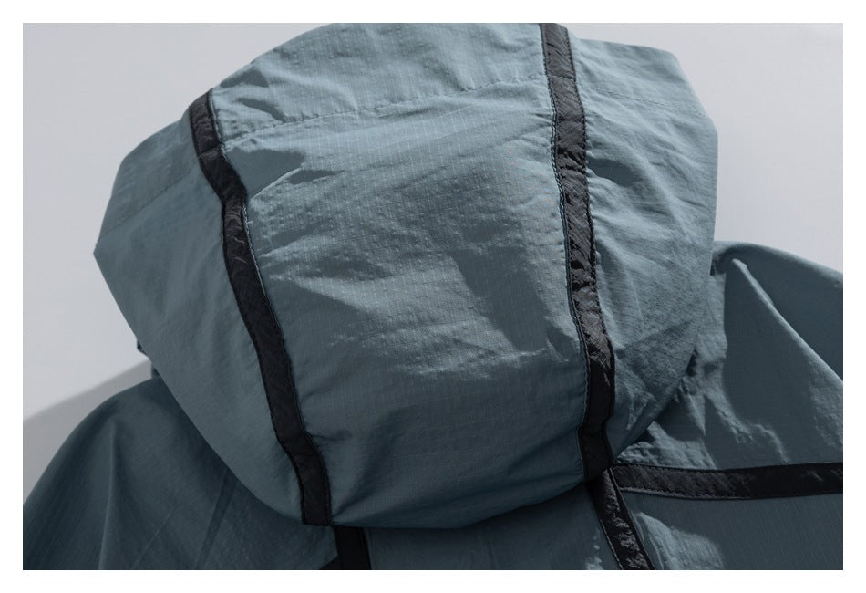 Close-up of a blue-gray hood with black seam trim and a subtle grid texture.