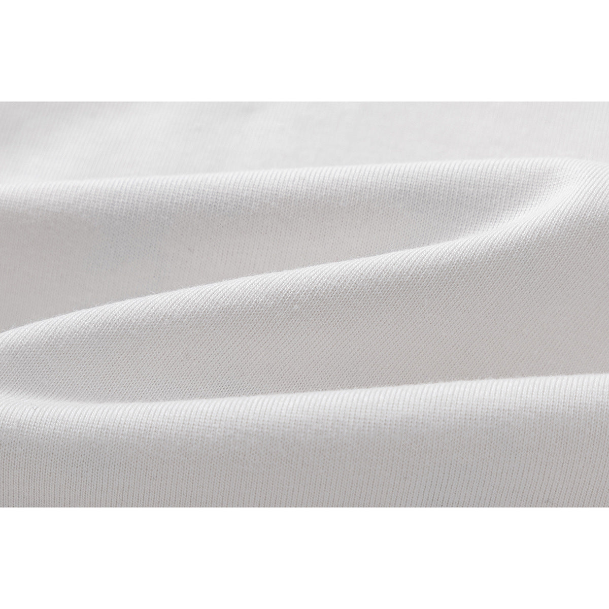 Macro view of white knit fabric arranged in soft folds.