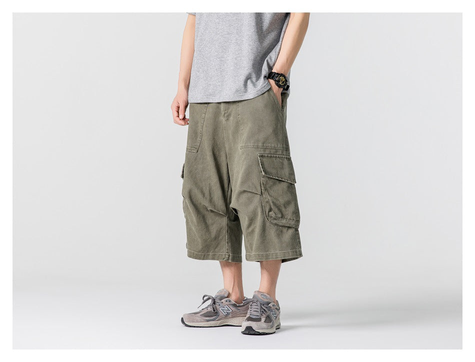 Front view of a model wearing olive knee-length cargo shorts with large flap cargo pockets.