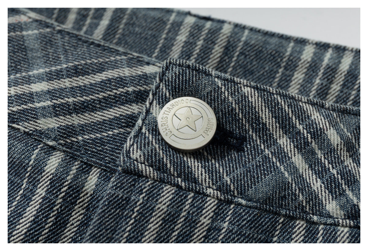 Close-up of a round metal button with a star emblem on dark blue and cream plaid fabric.