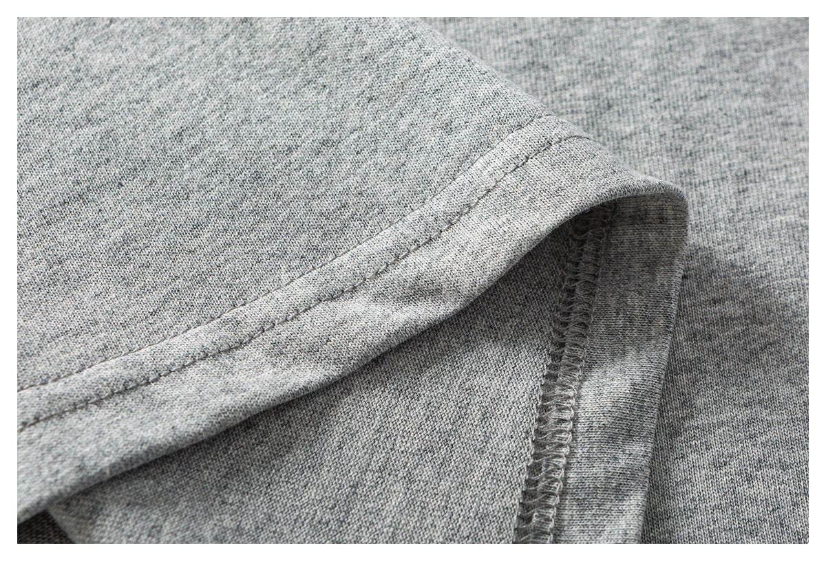 Close-up of a heather-gray garment hem with visible stitching and an overlocked seam.