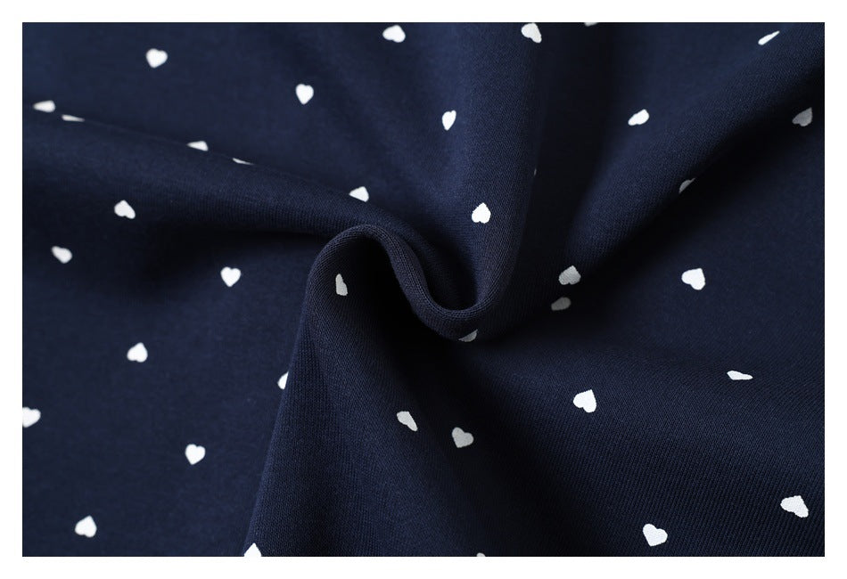 Close-up showing the drape and small white heart pattern of navy hoodie fabric.