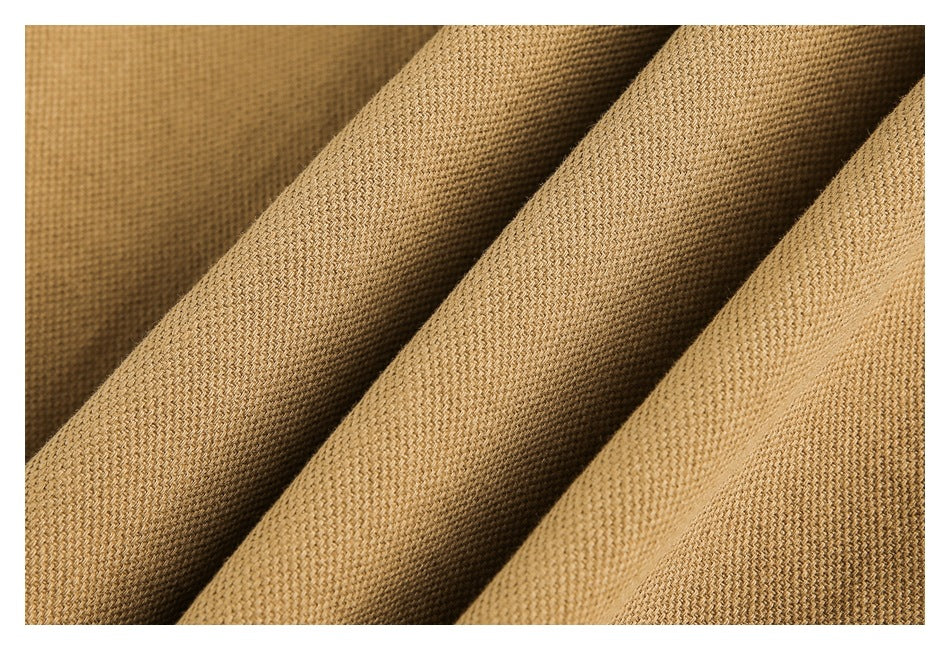 Macro view of tan woven garment fabric folded into soft ridges.