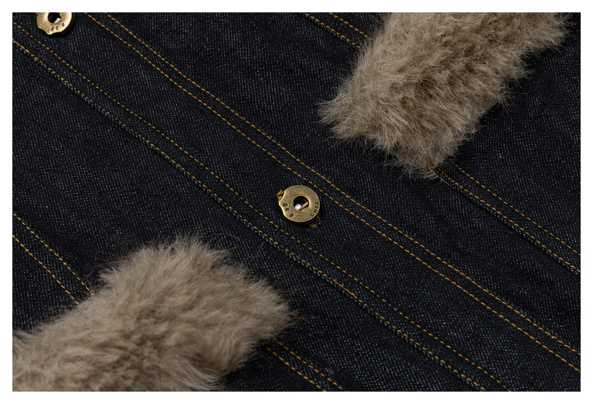 Close-up of dark indigo denim with tan stitching, brass buttons, and taupe fluffy trim.