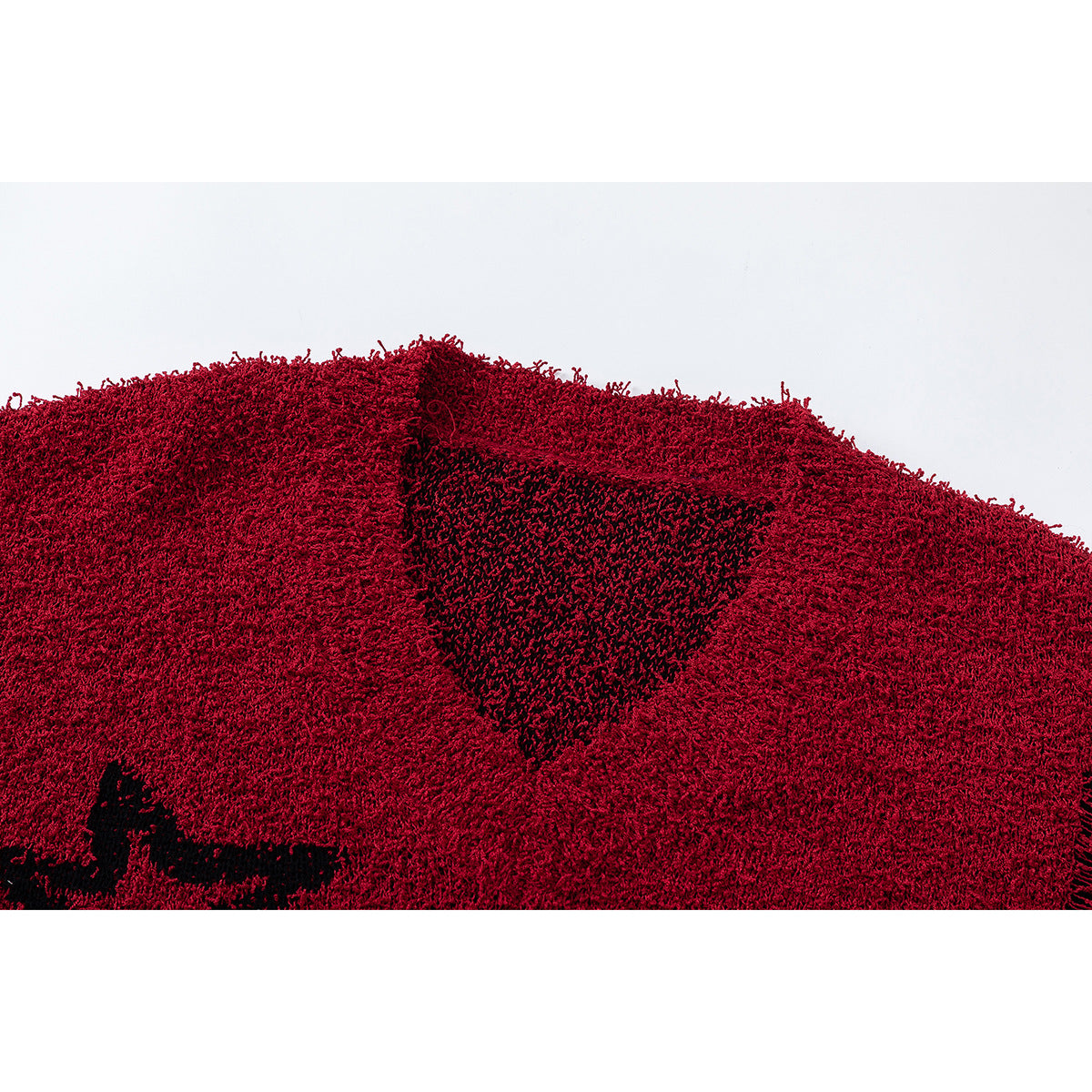 Close-up of a shaggy red scarf with a black knitted motif.