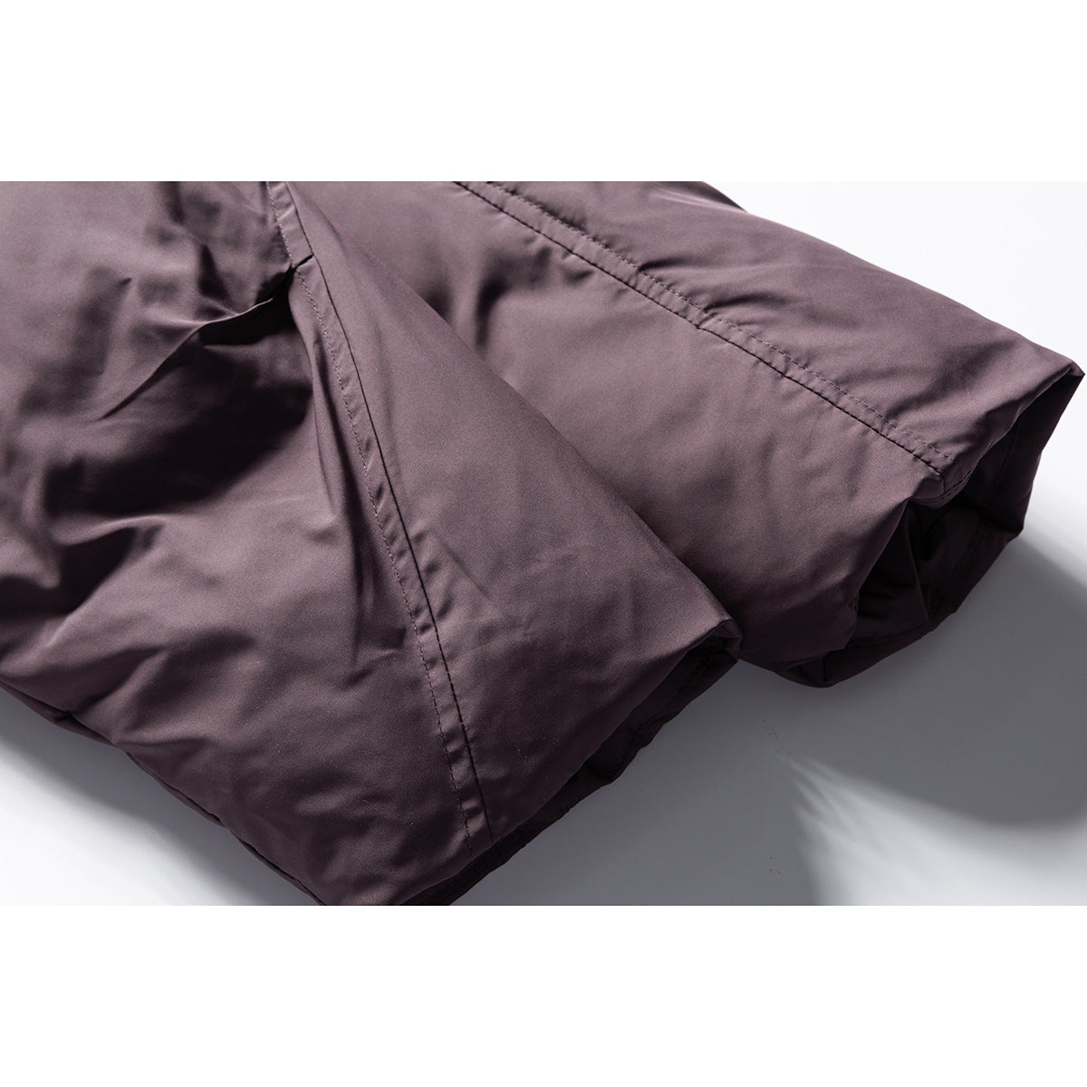 Close-up of the mauve jacket's sleeve and stitched panel seams.