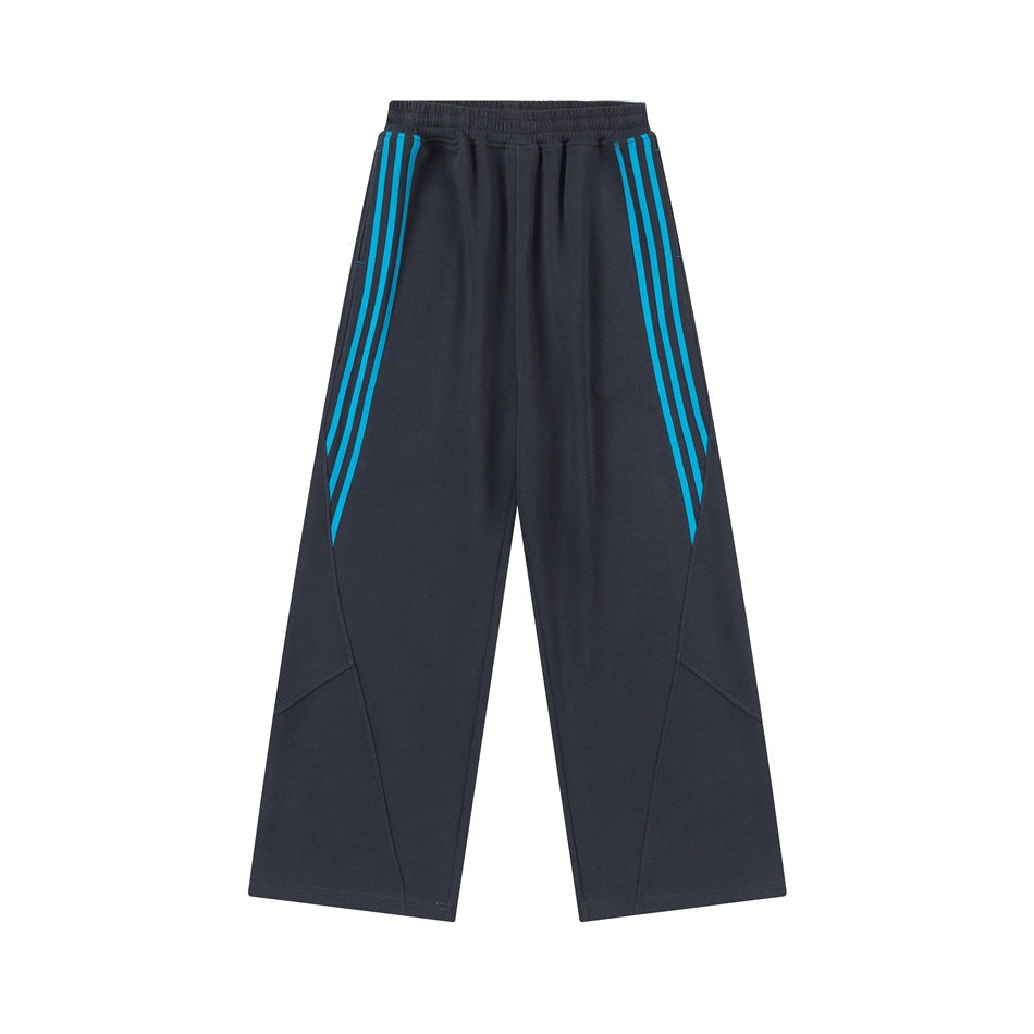Dark gray wide-leg sweatpants with blue triple side stripes, flat lay on white