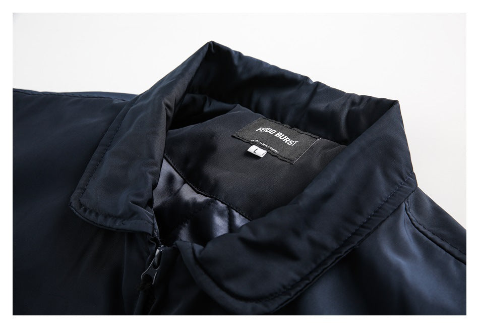 Close-up of a navy jacket's fold-down collar, zipper, and sewn-in neck label.