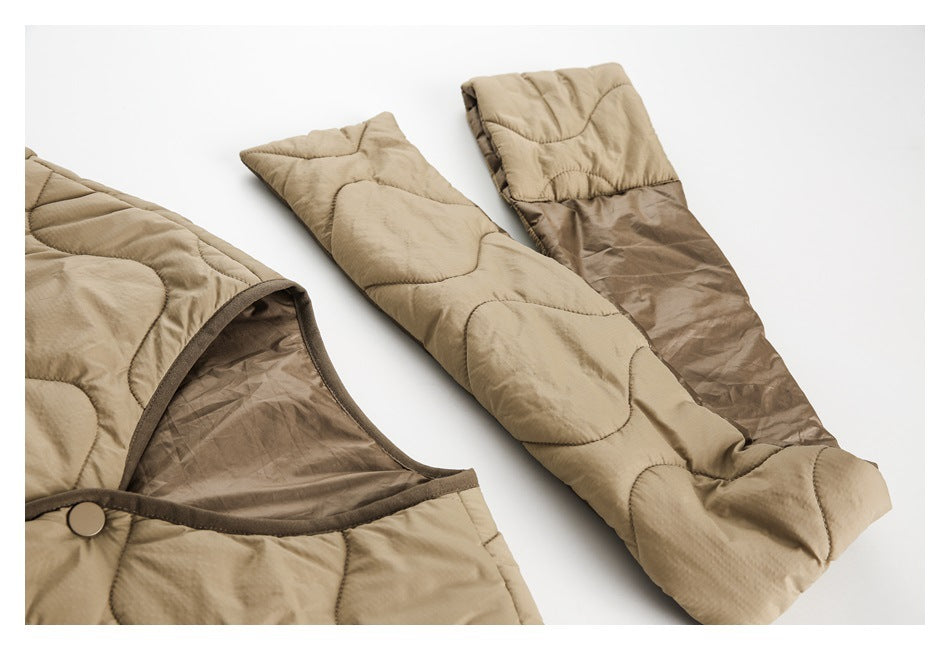 Close-up of tan quilted outerwear showing a curved opening, dark brown lining, and padded panels.