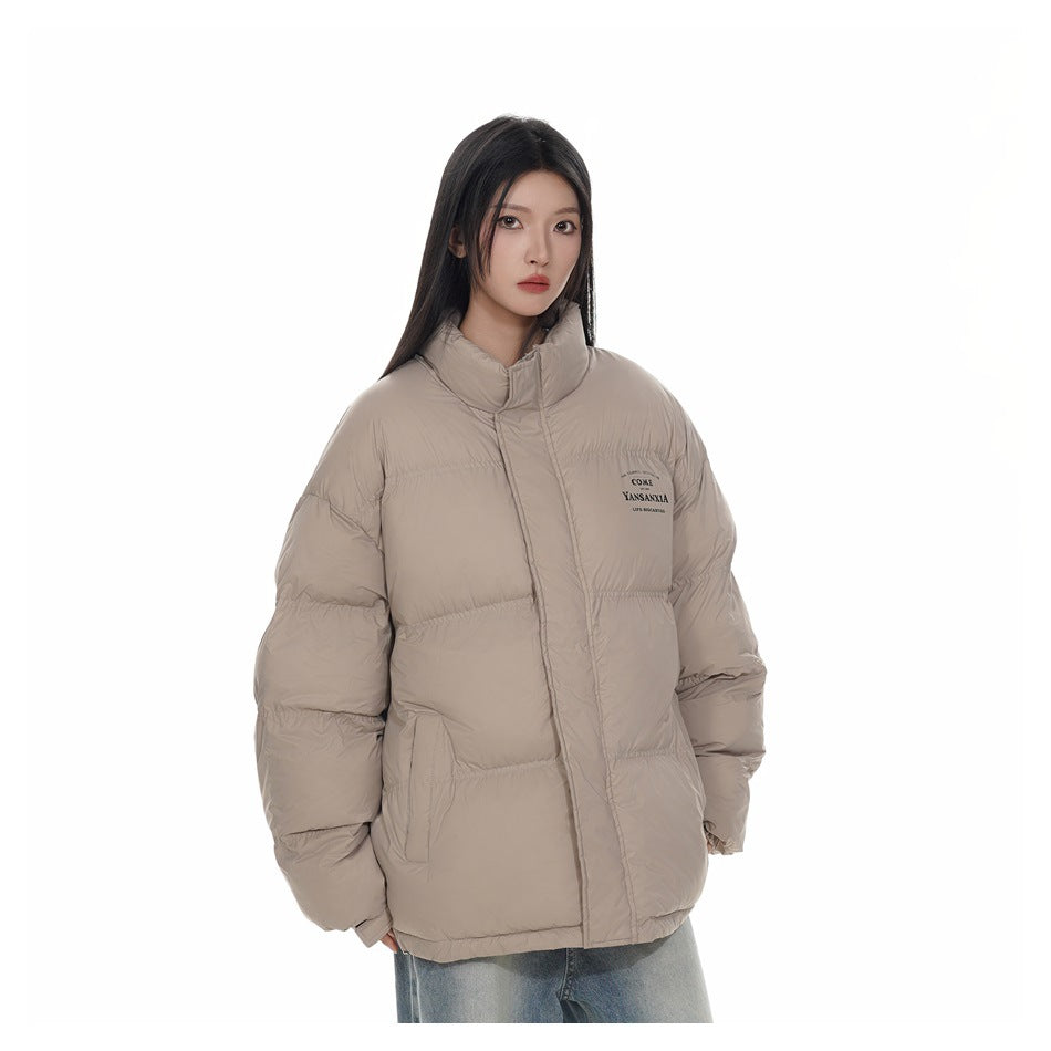 Model wearing a zipped light khaki puffer jacket with stand collar and light jeans, three-quarter view