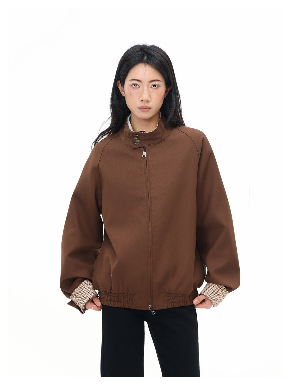 Model wearing a brown zip-front jacket with a buttoned stand collar, gathered hem, and beige checked cuffs.