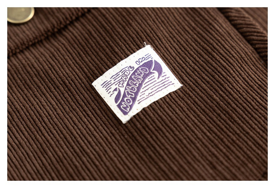 Macro view of a small purple-and-white sewn label on brown ribbed corduroy.