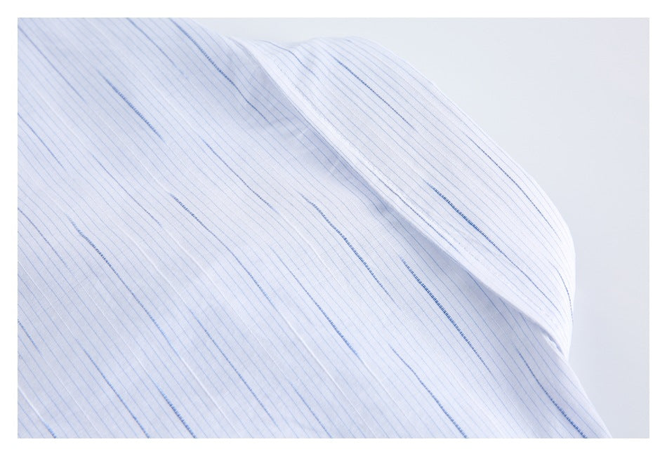 Close-up of a white shirt shoulder seam with fine blue stripes.