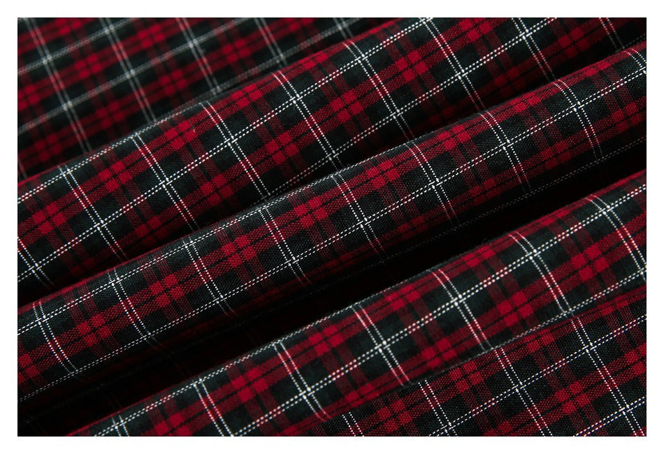 Close-up of red, black, and white plaid fabric arranged in soft folds.