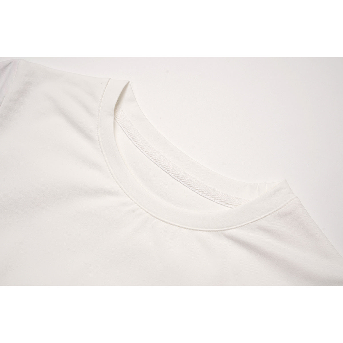 Close-up of a white top's rounded neckline and collar stitching.