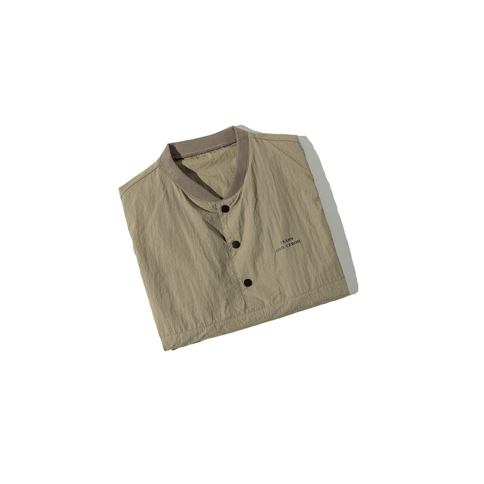 Folded olive-taupe sleeveless top with a ribbed neckline, three black snaps, and small chest lettering.
