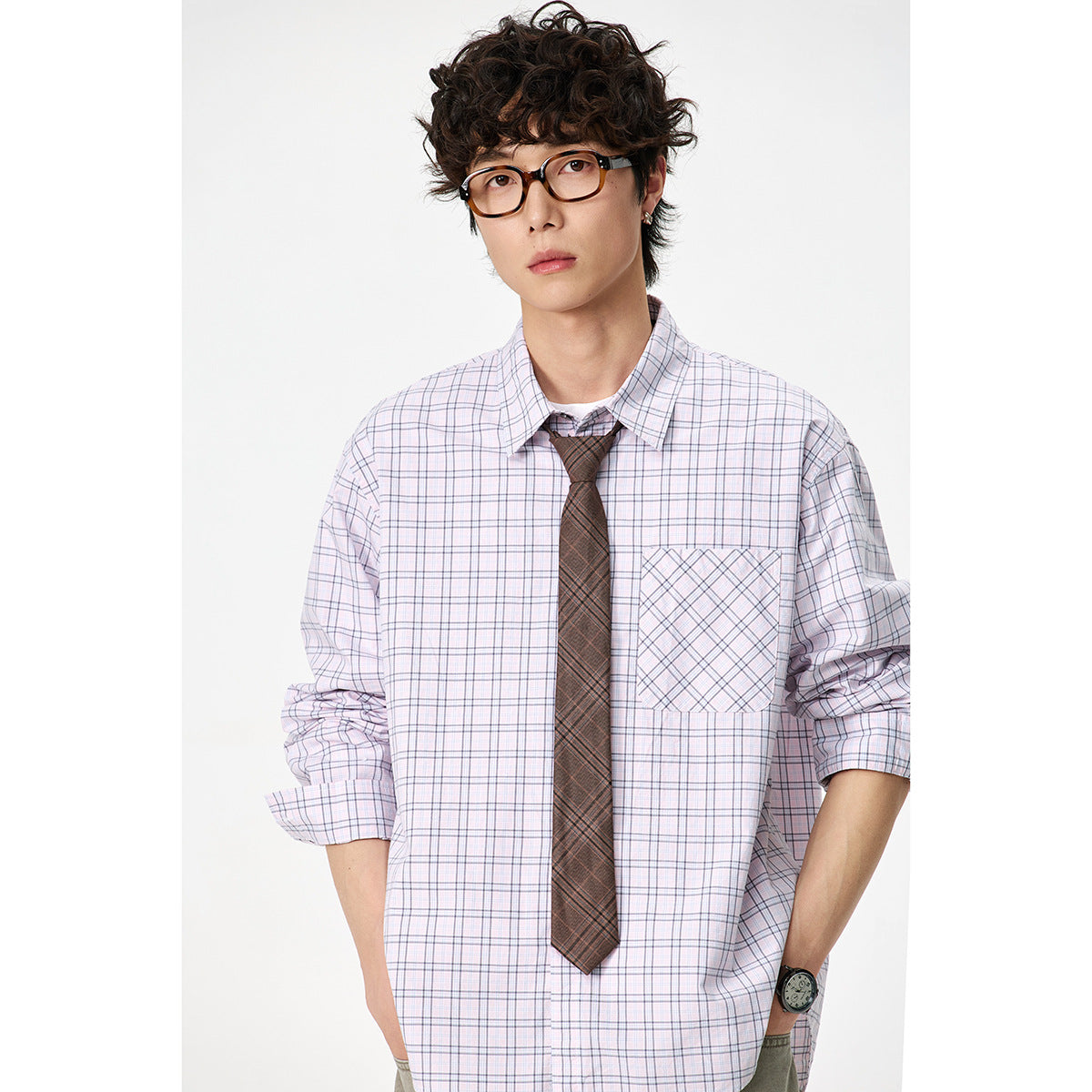 Close front view of a model wearing a pale lavender plaid button-down shirt with a diagonally patterned chest pocket and
