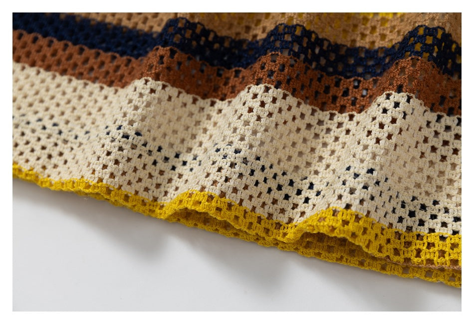 Close-up of the cream open-knit garment hem with mustard edging and navy, rust, and tan stripes.
