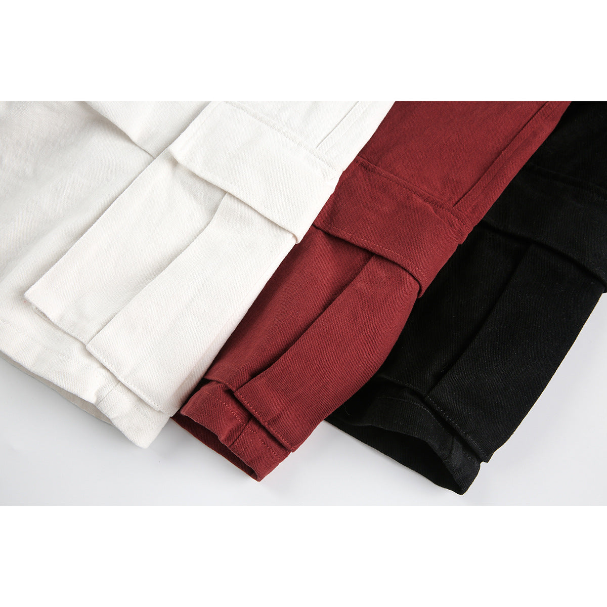 Close-up of the folded hems of white, burgundy, and black shorts.