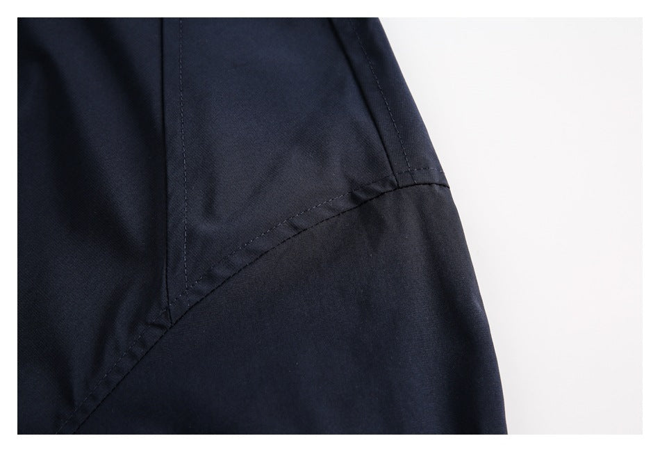 Close-up of curved stitched seams on a dark navy garment.