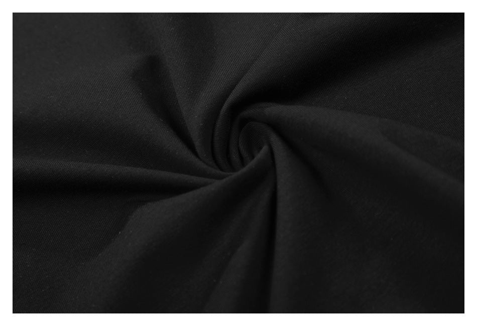 Close-up of black shirt fabric gathered into folds to show its surface and drape.