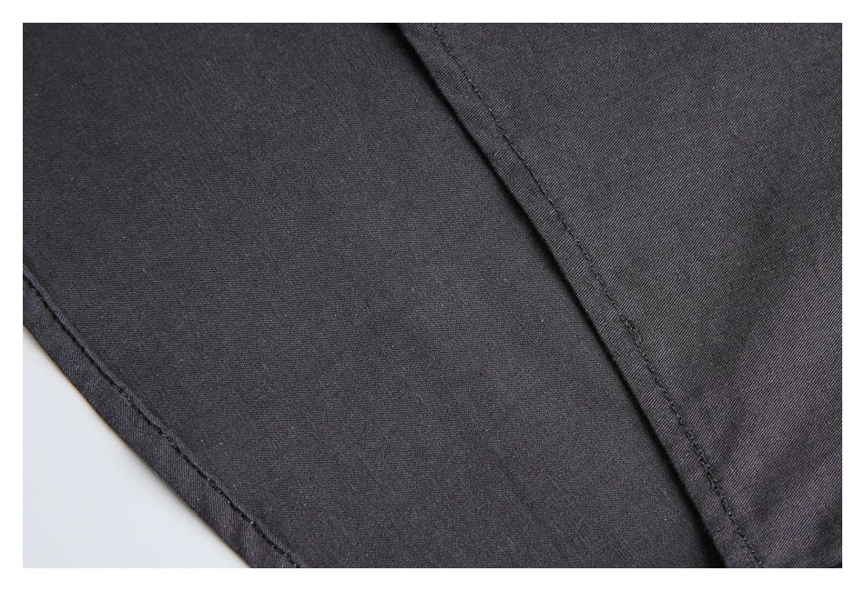 Close-up of charcoal fabric with a diagonal stitched seam and finished edge.