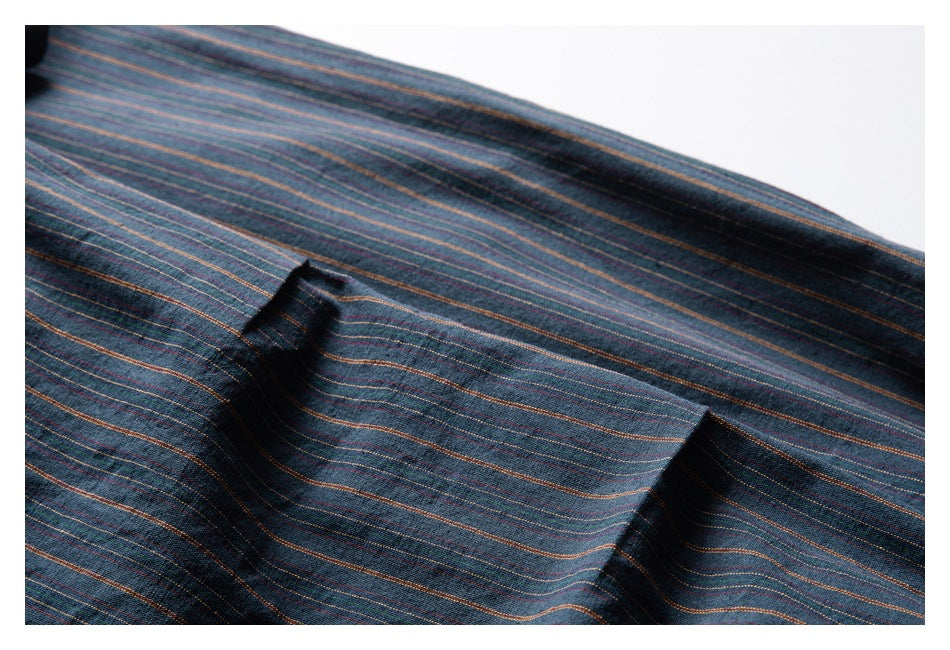 Close-up of a pocket opening on dark blue fabric with fine multicolor stripes.