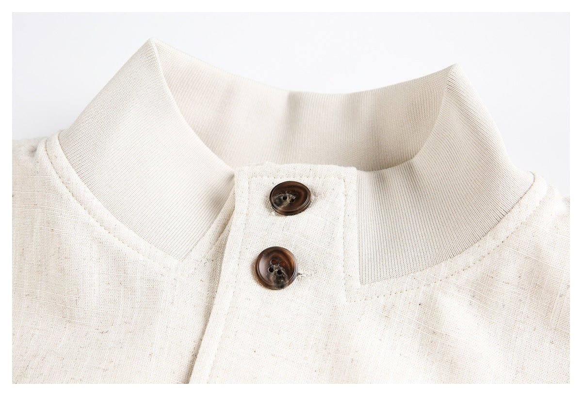 Close-up of the cream jacket's stand collar and two dark brown buttons.