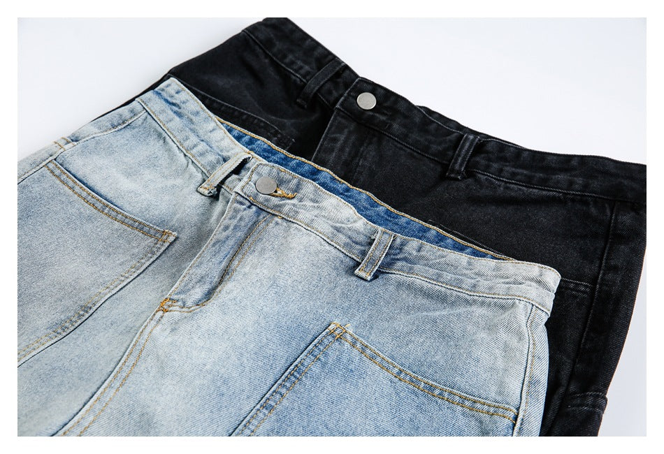 Close-up of light-wash and black jeans overlapping, showing their waistbands, buttons, belt loops, and pockets.