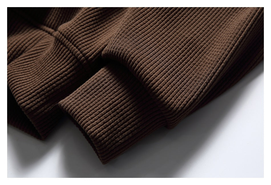 Close-up of the brown hoodie’s ribbed sleeve cuff and hem edge.
