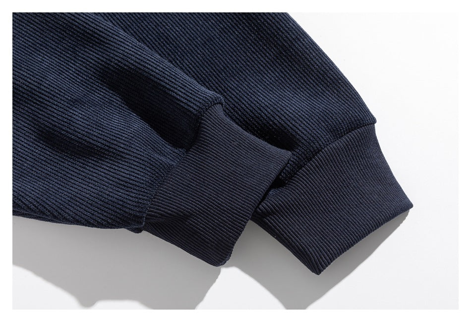 Close-up of a dark navy ribbed sleeve ending in a wide ribbed cuff.