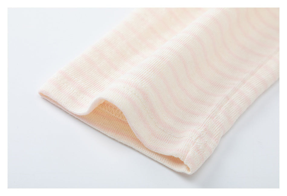 Close-up of the opening and stitched edge of a pale pink and cream striped garment.