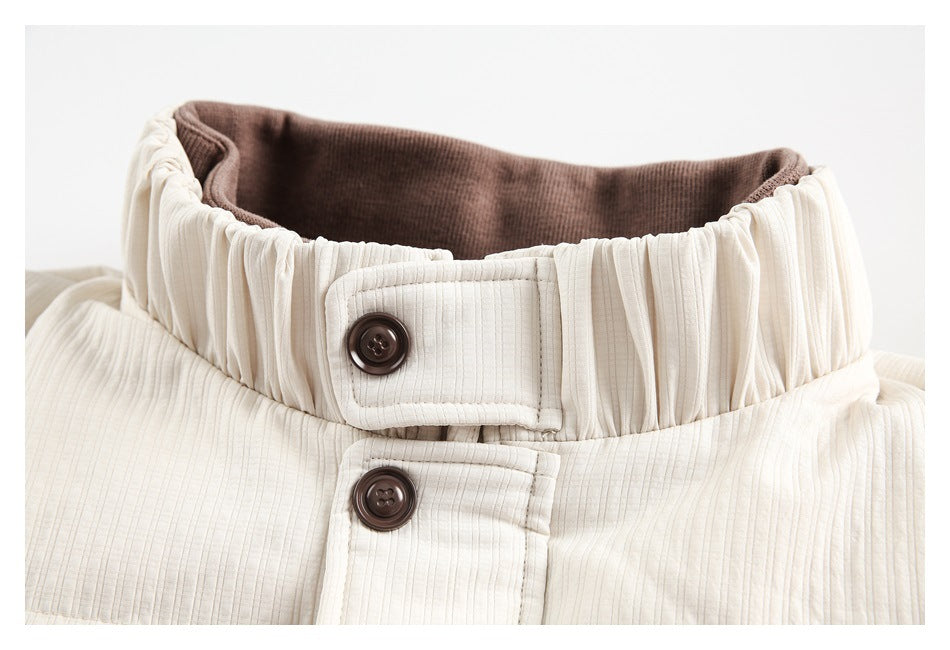 Close-up of an ivory jacket's gathered high collar, brown buttons, and brown inner lining.
