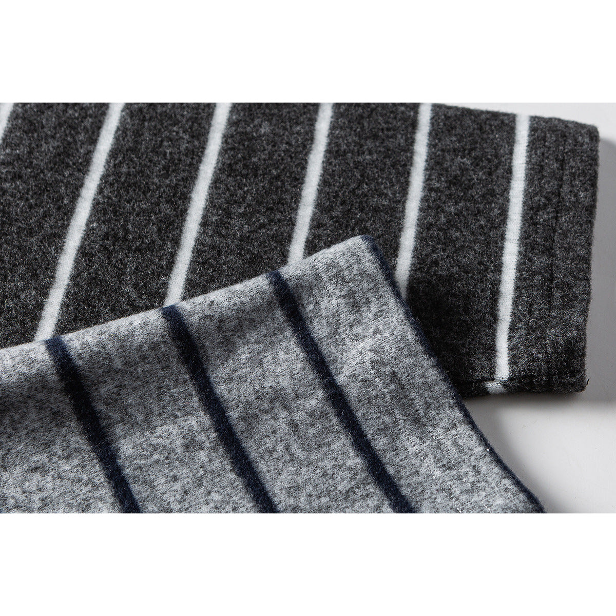 Close-up of gray and charcoal striped fabric folded to show the contrasting stripe pattern.