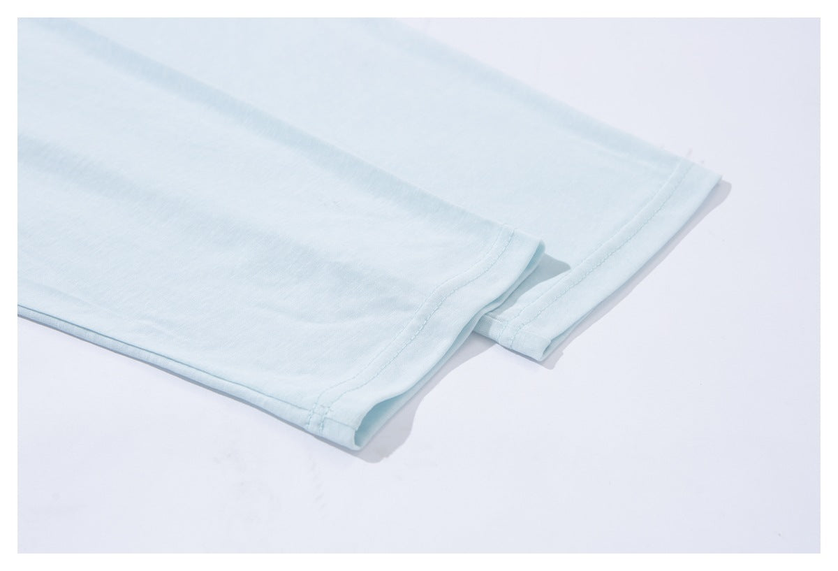 Close-up of the pale blue T-shirt's sleeve ends and stitched hems on a white background.