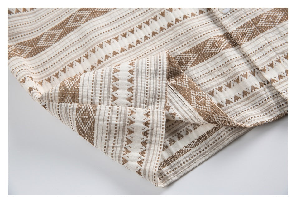 Close-up of the patterned shirt's sleeve cuff and hem, showing cream fabric with tan geometric stripes.