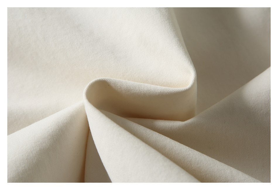 Close-up of ivory fabric folded to show its smooth surface and drape.