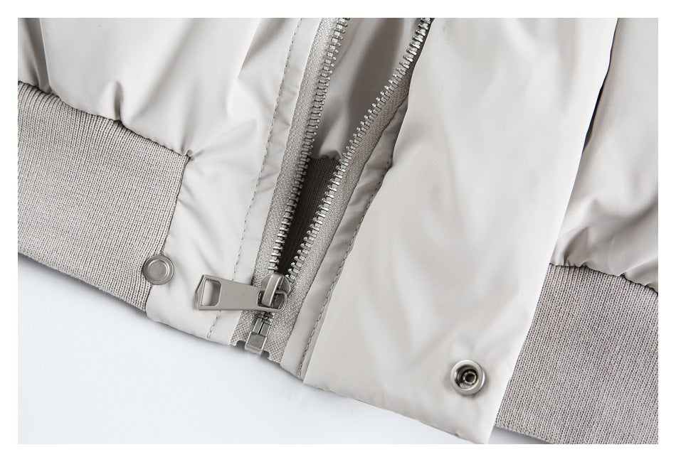 Close-up of the coat's front zipper, snap fasteners, and ribbed knit hem.