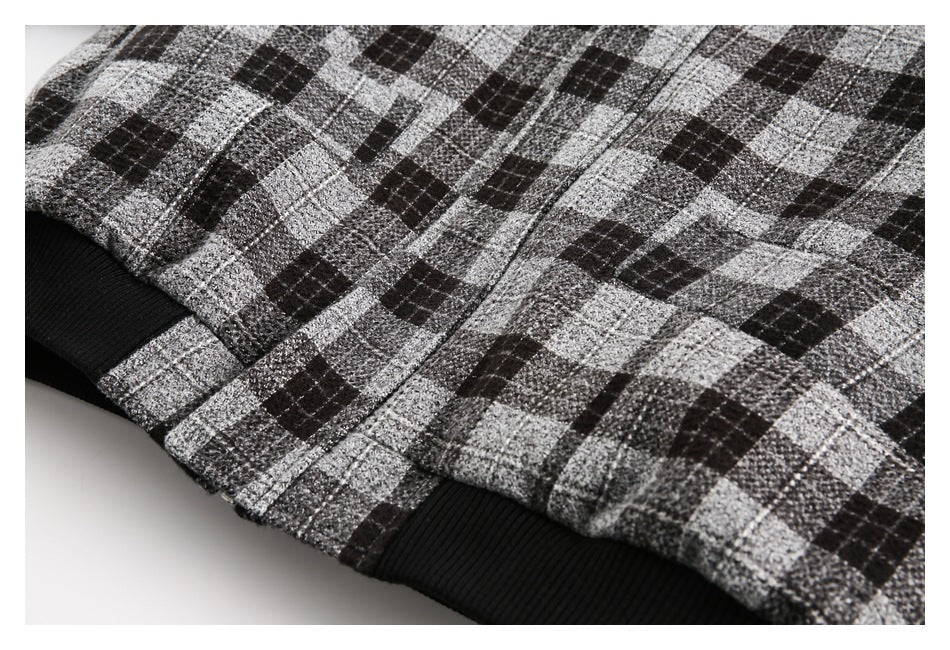 Close-up of the jacket's plaid lower edge and black ribbed hem.