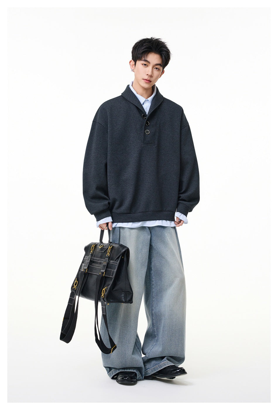 Full-length model wearing a charcoal oversized three-button pullover with wide-leg faded jeans.