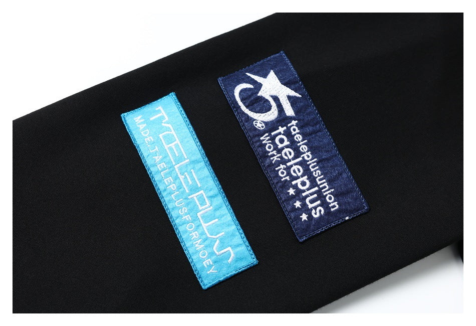 Close-up of two blue embroidered rectangular patches on black fabric.