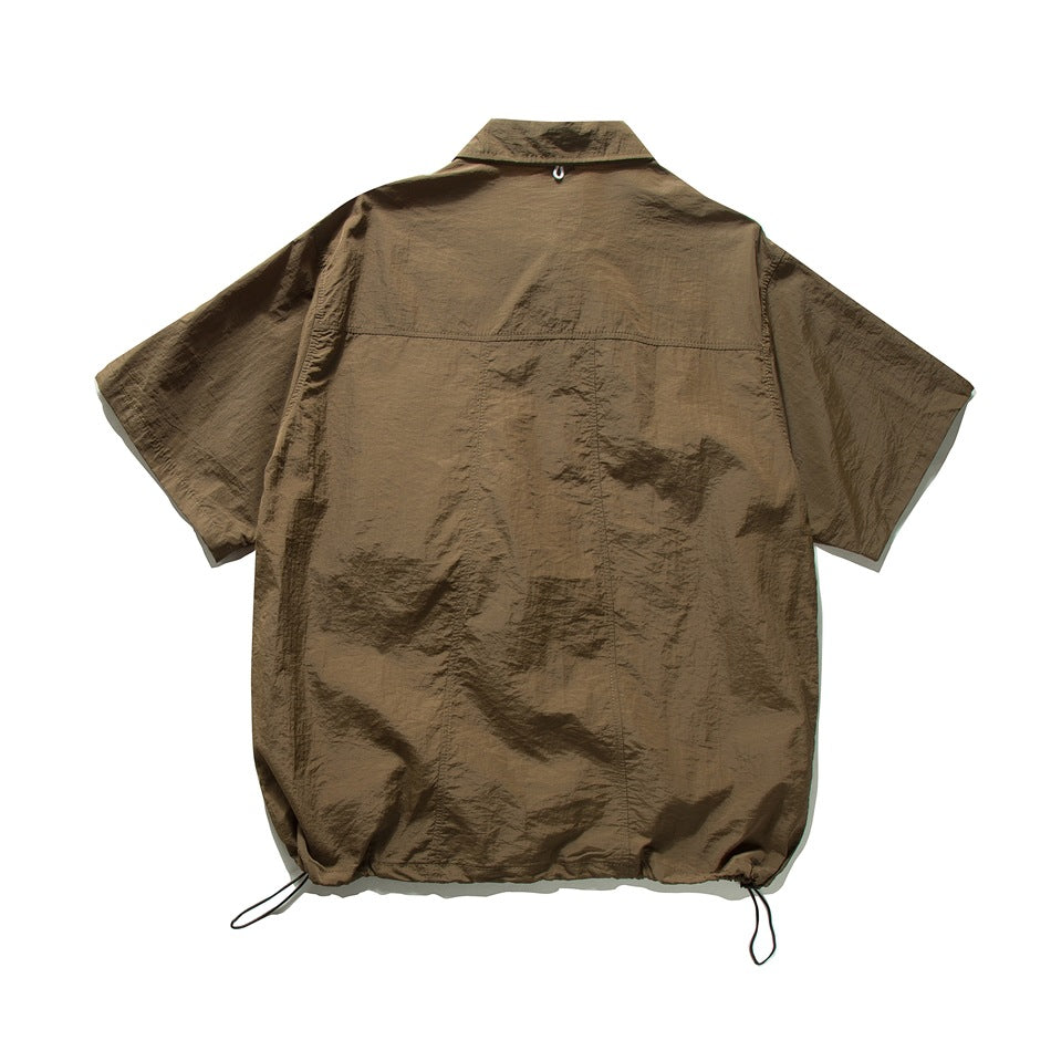 Back view of an olive-brown short-sleeve collared shirt with a yoke seam and drawcord hem.