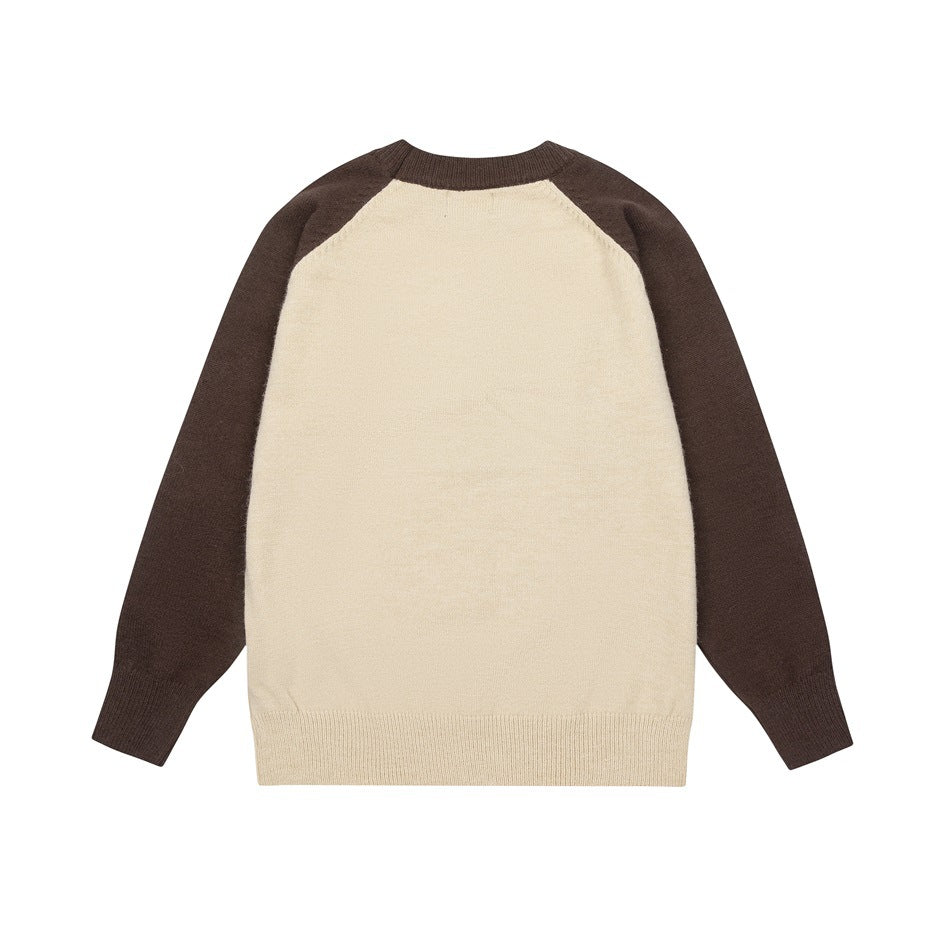 Flat-lay front view of a cream knit sweater with dark brown raglan sleeves and ribbed trim.