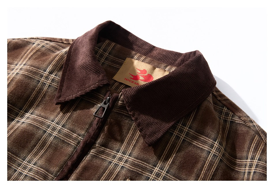 Close-up of a brown plaid jacket's dark corduroy collar, zipper, and sewn neck label.