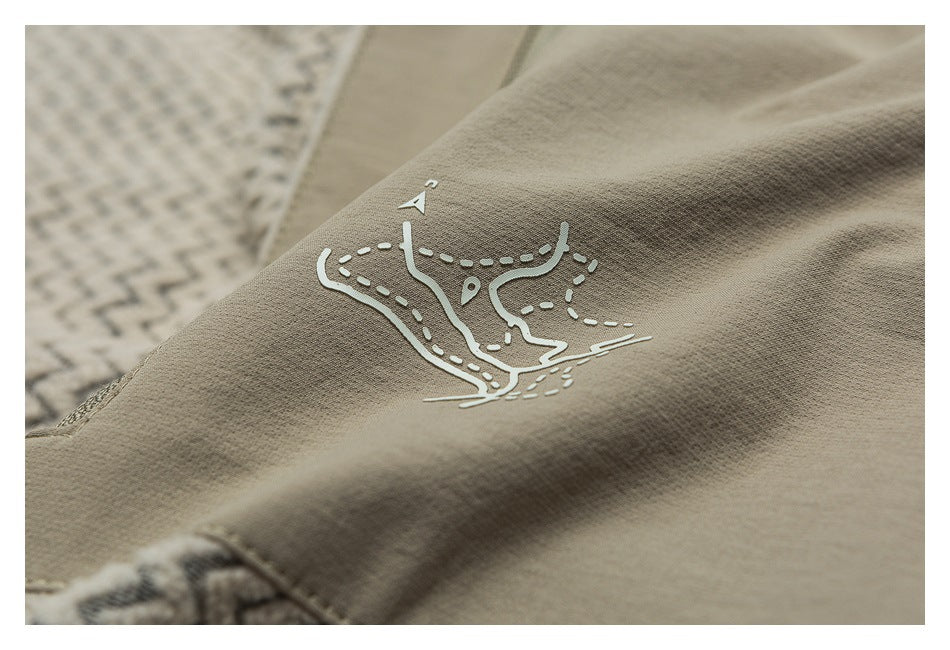 Close-up of taupe fabric featuring a white map-like graphic and visible stitching.