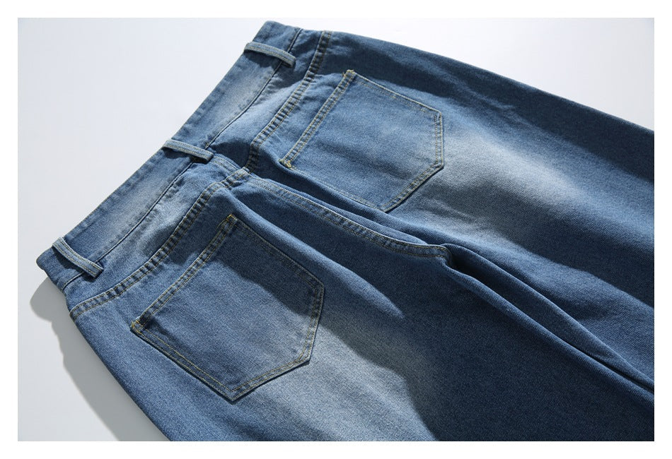 Blue faded jeans laid flat, back view showing two stitched rear pockets and belt loops.